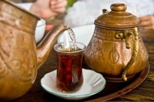 Drinking traditional Turkish Tea with Turkish tea cup and copper tea pot.